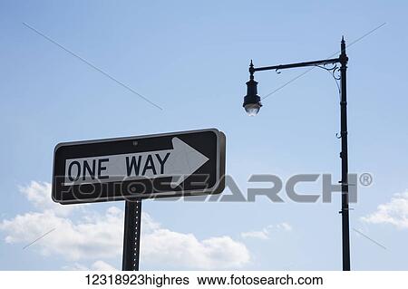 Stock Photograph - 'One Way' traffic sign and a street light; Connecticut, United States of America. Fotosearch