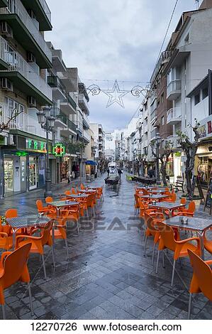 Stock Photograph - Orange chairs and tables on an outdoor patio; Benidorm, Spain. Fotosearch