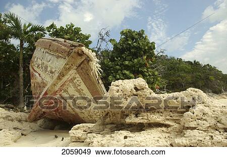 Paint Peeling Off Of Red And White Wooden Rowboat Resting On Rocky Seashore On Halfmoon Quay In The Bahamas. View Large Photo Image Stock Photo - Paint Peeling Off Of Red And White Wooden Rowboat Resting On Rocky Seashore On Halfmoon Quay In The Bahamas.. Fotosearch