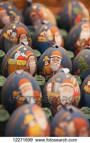 Stock Photo - Painted egg Christmas tree decorations for sale in a souvenir shop, showing Father Christmas/St Nicholas with toys and a sack of presents; Salzburg, Austria. Fotosearch