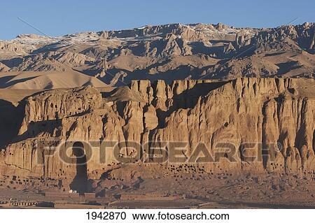 Panoramic View Of Bamiyan And The Escarpment With Hundreds Of Caves And The Niche That Contained The Large Buddha Statue Destroyed By The Taliban In 2001, Bamian Province, Afghanistan View Large Photo Image Stock Image - Panoramic View Of Bamiyan And The Escarpment With Hundreds Of Caves And The Niche That Contained The Large Buddha Statue Destroyed By The Taliban In 2001, Bamian Province, Afghanistan. Fotosearch