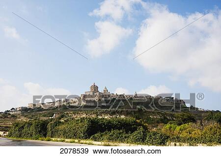 Stock Photo - Panoramic View Of Mdina With Cathedral Of Saint Peter & Saint Paul From The Countryside Below, Mdina, Malta. Fotosearch