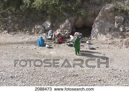 Stock Image - Pashtun Women Collecting Water By A Stream In The Khyber Pass, Federally Administered Tribal Areas, Pakistan. Fotosearch