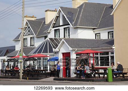 Stock Image - Patrons on an outdoor restaurant patio of Bayview Hotel; Waterville, County Kerry, Ireland. Fotosearch