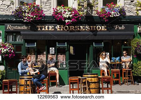 Patrons sitting outside a pub; Kenmare, County Kerry, Ireland View Large Photo Image Stock Image - Patrons sitting outside a pub; Kenmare, County Kerry, Ireland. Fotosearch