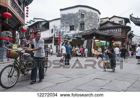 Picture - Pedestrians in a small village with traditional chinese architecture, near Wuyuan; Jiangxi province, China. Fotosearch