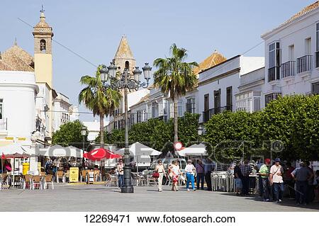 Stock Image - Pedestrians in a town square; Medina Sidonia, Andalusia, Spain. Fotosearch