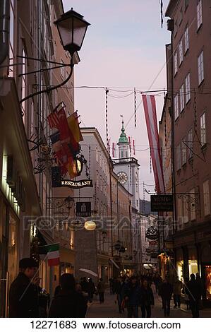 Pedestrians on narrow streets with shops, hotels and restaurants in the historic centre at dusk; Salzburg, Austria View Large Photo Image Stock Image - Pedestrians on narrow streets with shops, hotels and restaurants in the historic centre at dusk; Salzburg, Austria. Fotosearch