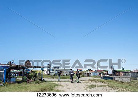 Pedestrians walking on the sandy path by buildings and hostels on the coast; Cabo Polonia, Uruguay View Large Photo Image Stock Photograph - Pedestrians walking on the sandy path by buildings and hostels on the coast; Cabo Polonia, Uruguay. Fotosearch