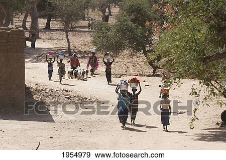 Stock Photo - People carrying baskets on their head, Baniani, Mali. Fotosearch