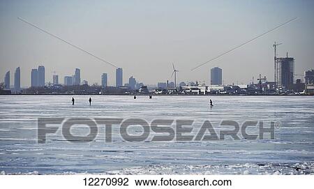 People in the distance on the ice against city skyline from Ward's Island; Toronto, Ontario, Canada View Large Photo Image Stock Image - People in the distance on the ice against city skyline from Ward's Island; Toronto, Ontario, Canada. Fotosearch