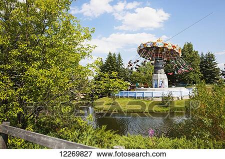 Stock Photo - People on a swing ride in an amusement park; Calgary, Alberta, Canada. Fotosearch