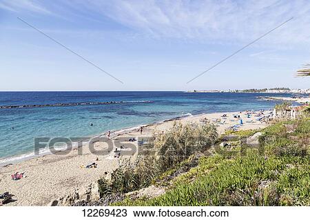 Stock Image - People on the beach on the mediterranean coast; Paphos, Cyprus. Fotosearch