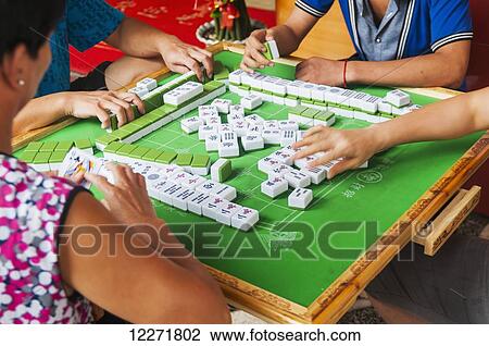Stock Image - People playing Majiang on the street; Xiamen, Fujian province, China. Fotosearch