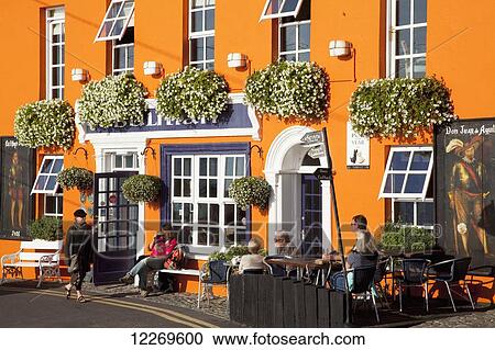 People sitting and walking outside a bright yellow building; Kinsale, County Cork, Ireland View Large Photo Image Stock Image - People sitting and walking outside a bright yellow building; Kinsale, County Cork, Ireland. Fotosearch