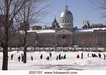 Stock Photo - People Skating On Ice Skating Ring In Montreal's Old Port With Bonsecours Market In The Background, Wintertime, Montreal, Quebec. Fotosearch