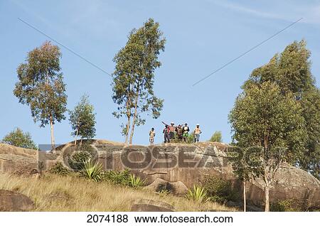 Stock Photo - People Standing On A Rock Along The Road Between Ambositra & Ambavalao, Fianarantsoa Province, Madagascar. Fotosearch