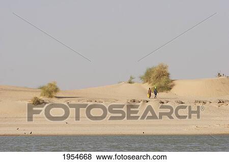 People walking along the shores of the Niger River between Niafunke and Kabara, Mali View Large Photo Image Stock Photo - People walking along the shores of the Niger River between Niafunke and Kabara, Mali. Fotosearch