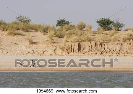 Stock Photo - People walking along the shores of the Niger River between Niafunke and Kabara, Mali. Fotosearch