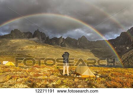Stock Image - Photographer taking pictures of the late afternoon light hitting the mountains in the Tombstone Territorial Park of the northern Yukon; Yukon, Canada. Fotosearch