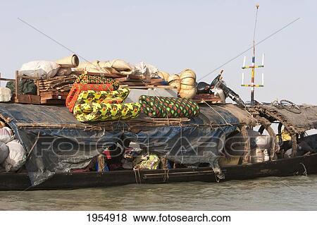 Stock Photo - Pinasse carrying cargo and passengers on the Niger River between Mopti and Lake Debo, Mali. Fotosearch