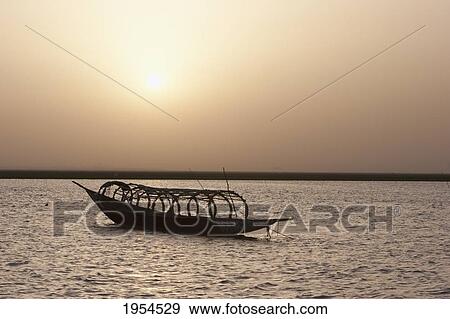 Pinasse in the sunset over Lake Debo, formed by the seasonal flooding of the Niger River, Mali View Large Photo Image Stock Photo - Pinasse in the sunset over Lake Debo, formed by the seasonal flooding of the Niger River, Mali. Fotosearch