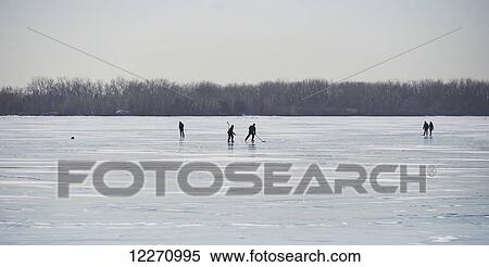 Stock Photography - Playing hockey on frozen harbor of Ward's Island; Toronto, Ontario, Canada. Fotosearch