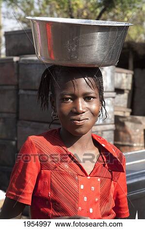 Portrait of a girl carrying container on head in Bamako, Mali View Large Photo Image Stock Photo - Portrait of a girl carrying container on head in Bamako, Mali. Fotosearch