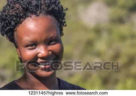 Stock Photograph - Portrait of an African woman smiling; South Africa. Fotosearch