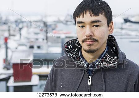 Stock Photo - Portrait of an Alaskan native man in front of the Homer small boat harbor, Homer Spit, Southcentral Alaska. Fotosearch
