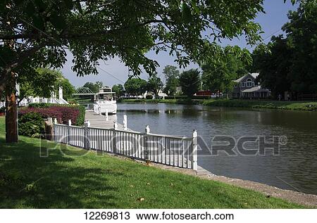 Stock Image - Private yacht tied along canal side and green lawn; Spencerport, New York, United States of America. Fotosearch