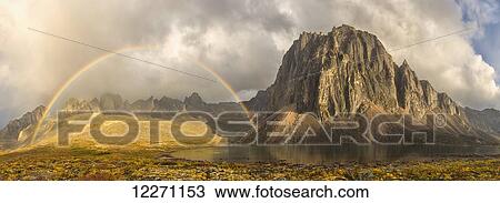 Stock Image - Rainbow over unnamed mountain by Talus Lake in Tombstone Territorial Park; Yukon, Canada . Fotosearch