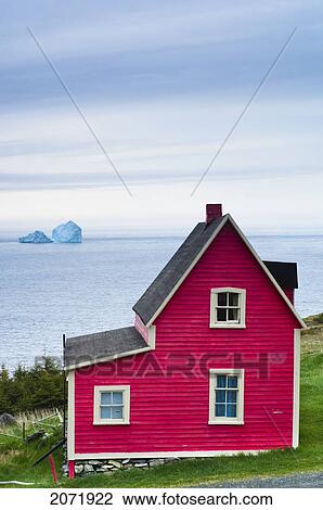 Stock Image - Red Cabin With Icebergs In The Background, Newfoundland. Fotosearch