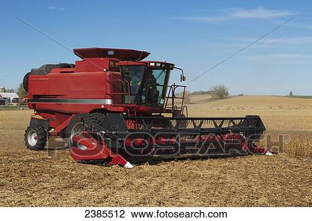 Stock Image - Red combine harvesting beans on a sunny autumn day in Northeast Iowa; Iowa, United States of America. Fotosearch