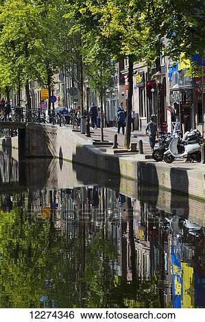 Stock Photograph - Reflections of buildings in a canal; Amsterdam, Holland. Fotosearch