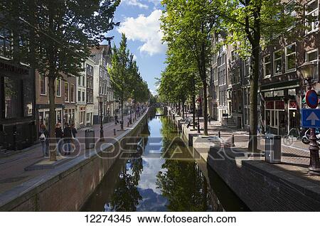 Reflections of trees in a canal, with pedestrians and buildings; Amsterdam, Holland View Large Photo Image Stock Photography - Reflections of trees in a canal, with pedestrians and buildings; Amsterdam, Holland. Fotosearch