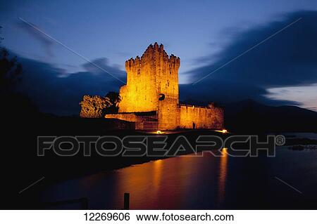 Stock Photograph - Ross Castle illuminated at nighttime; Killarney, County Kerry, Ireland. Fotosearch
