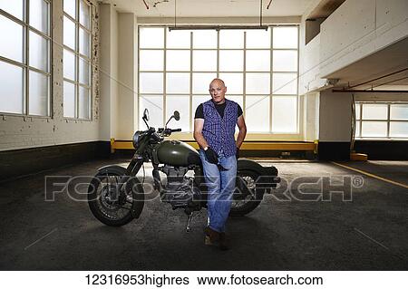 Royal Enfield Cafe Cruiser and it's owner in parking garage; Toronto, Ontario, Canada View Large Photo Image Stock Photograph - Royal Enfield Cafe Cruiser and it's owner in parking garage; Toronto, Ontario, Canada. Fotosearch
