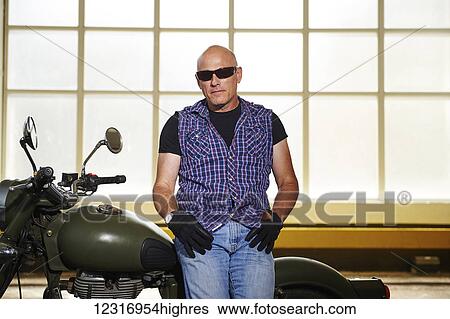 Royal Enfield Cafe Cruiser and it's owner in parking garage; Toronto, Ontario, Canada View Large Photo Image Stock Photograph - Royal Enfield Cafe Cruiser and it's owner in parking garage; Toronto, Ontario, Canada. Fotosearch