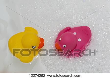 Stock Image - Rubber ducks facing each other in a bubble bath; Chilliwack, British Columbia, Canada. Fotosearch