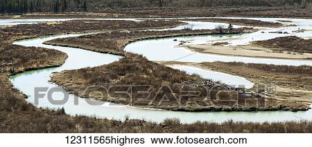Stock Photograph - S curves of a river's delta with brown bush in the late autumn; Calgary, Alberta, Canada. Fotosearch