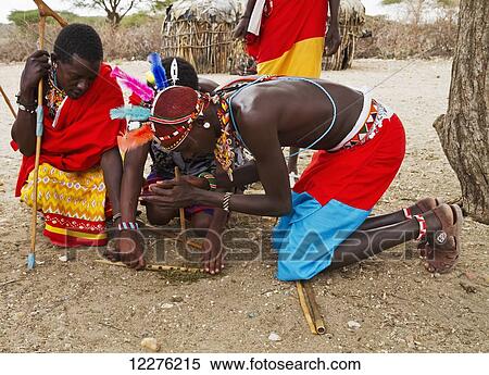 Stock Photography - Samburu men lighting a fire, Samburu County; Kenya. Fotosearch