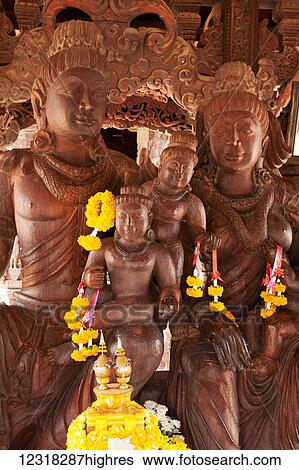Stock Photograph - Sanctuary of Truth wooden building with hundreds of carved Buddhist figures; Pattaya, Thailand. Fotosearch