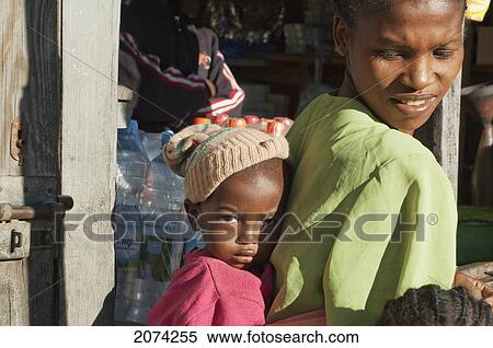 Stock Photography - Scared Young Boy Gets Closer To His Mother In Ranohira, Fianarantsoa Province, Madagascar. Fotosearch