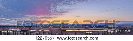 Stock Photo - Scenic sunset over the village of Noatak, Baird Mountains, tundra, and wetlands, Arctic Alaska, Autumn. Fotosearch