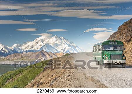Stock Photo - Scenic view of Mt. McKinley with a tour bus on the Park Road in the foreground, Denali National Park, Interior Alaska, Summer. Fotosearch