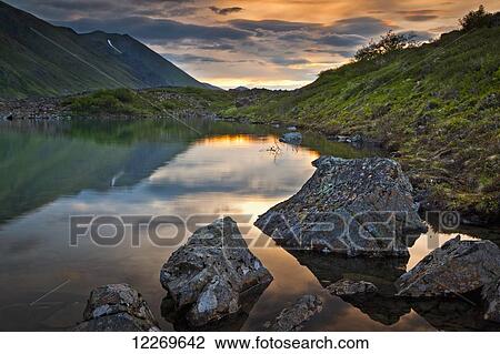 Stock Image - Scenic view of Symphony Lake at Sunset, Chugach Mountains, Chugach State Park, Southcentral Alaska, Summer. Fotosearch