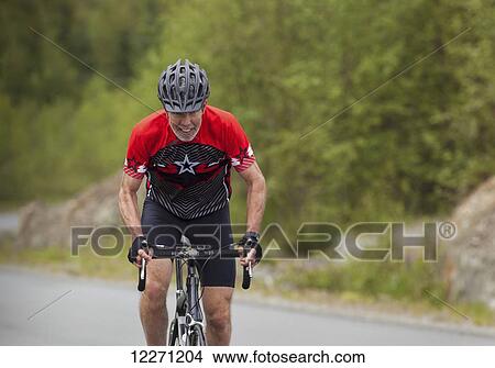 Picture - Senior male cyclist wearing helmet; Vancouver Island, British Columbia, Canada. Fotosearch
