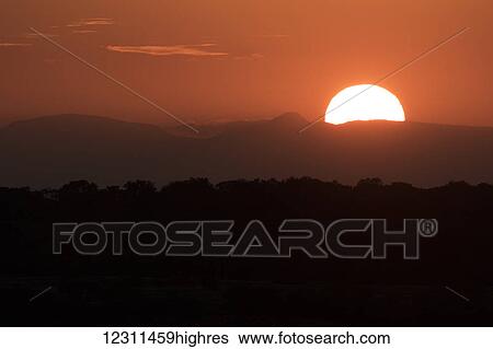 Stock Photograph - Setting sun overtop of the African landscape; South Africa. Fotosearch