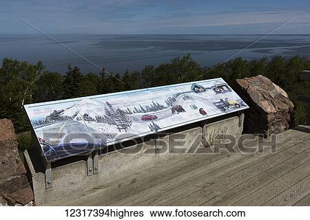 Stock Photograph - Sign with a winter driving scene overlooking the ocean, Cape Breton Island; Petit Etang, Nova Scotia, Canada. Fotosearch